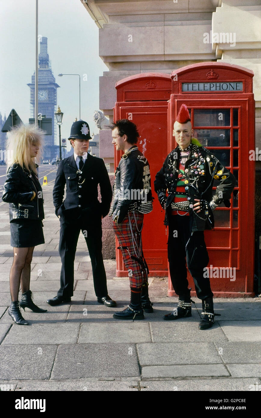 Three punks talking to a policeman by The Houses of Parliament. London. England. UK. Europe. Circa 1980's Stock Photo