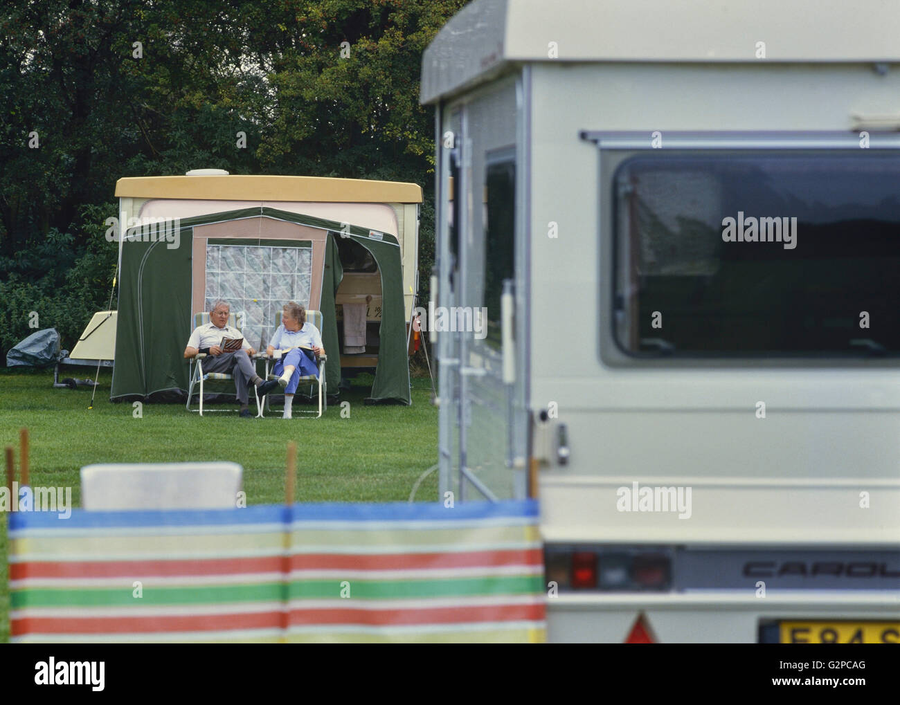 An elderly couple relaxing at a caravan park. Cambridgeshire. England. UK Stock Photo