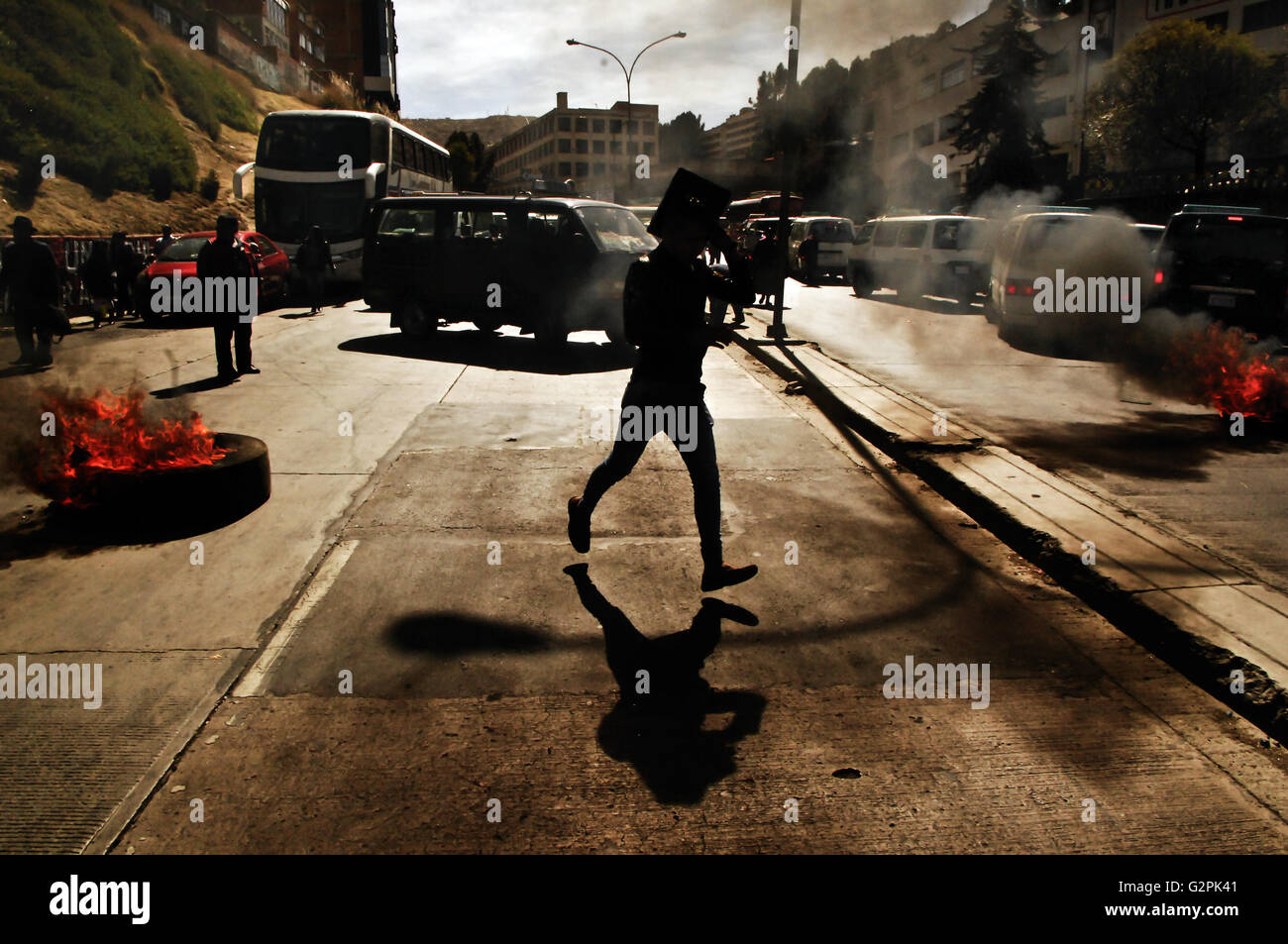 June 1, 2016 - La Paz, La Paz, Bolivia - People run away from protests in La Paz, Bolivai. Textile workers get to the La Paz city streets to protest against Evo Morales's government and his recent decision to get last ENATEX.SA public textile industry closed, as firing the all personal.Enatex was Ametex untill 2012, exporting clothes to the U.S for trademarks as Ralph Lauren, Hilfiger, and others. After failling in war on drugs U.S plans, Bolivia loose in 2008 her possibility to export with preferences and in 2012 the government buy and reduce it to export textiles to Venezuela new allies, sup Stock Photo