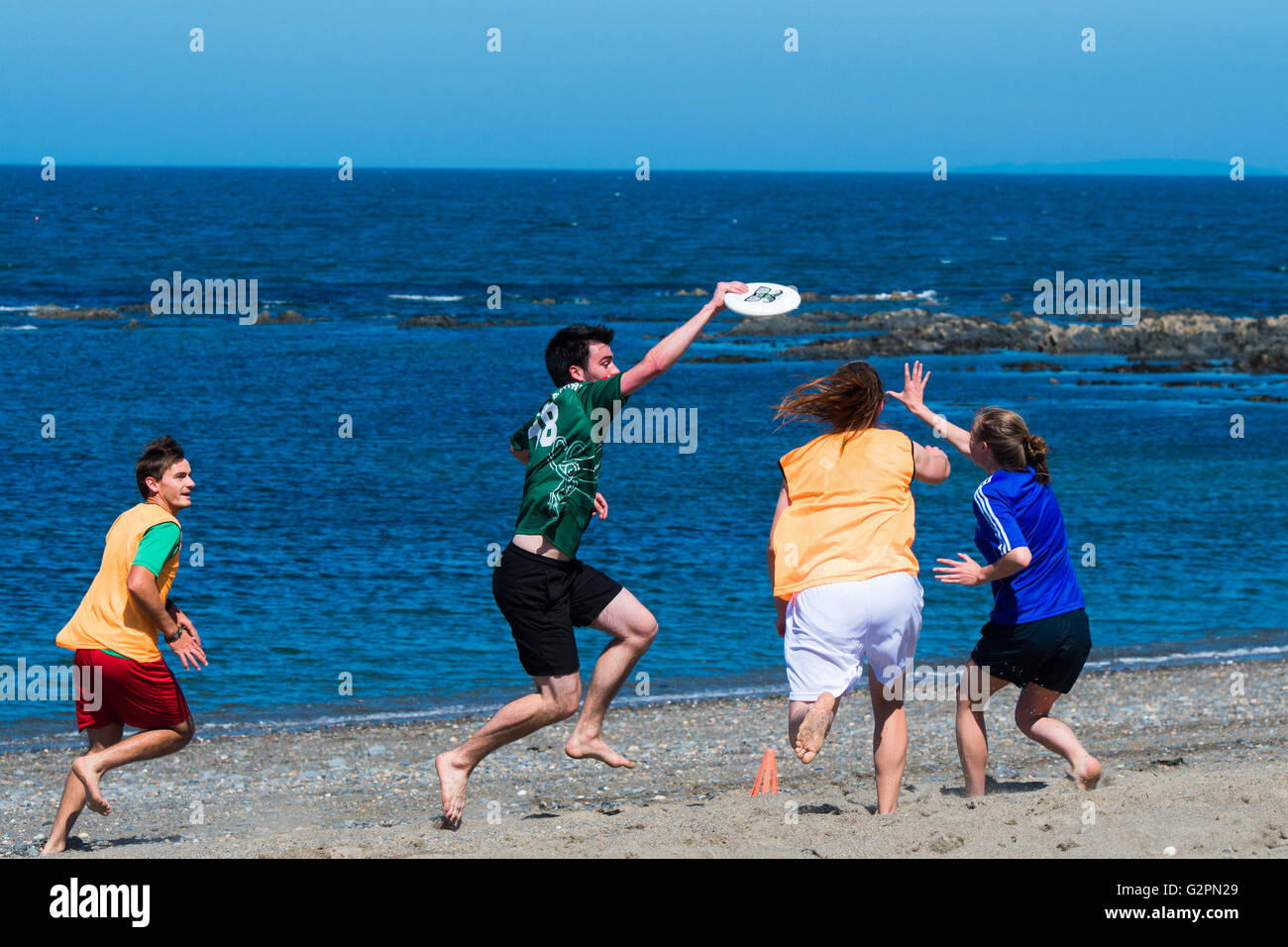 Aberystwyth Wales UK, Thursday 02 June 2016  UK weather: On the second ‘official’ day of summer students from Aberystwyth University 'Ultimate Frisbee' club  enjoy a morning of clear blue skies and warm sunny weather on the beach  on the Cardigan Bay coast of West Wales.   In contrast to the overcast and damp conditions in the east of the country, the temperature in Wales and the west country is expected to reach the low 20’s  centigrade.  photo Credit:  Keith Morris / Alamy Live News Stock Photo