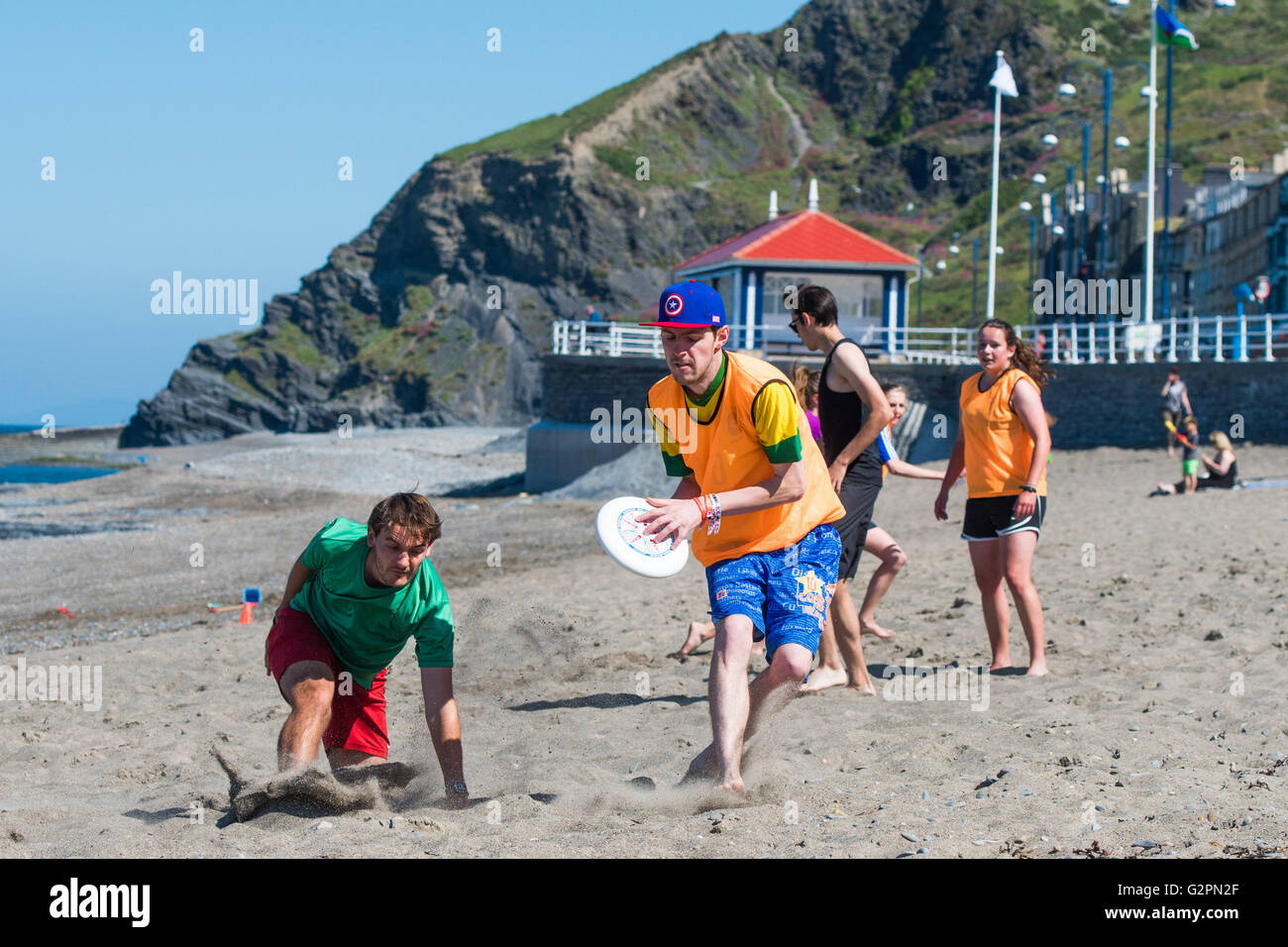 Aberystwyth Wales UK, Thursday 02 June 2016  UK weather: On the second ‘official’ day of summer students from Aberystwyth University 'Ultimate Frisbee' club  enjoy a morning of clear blue skies and warm sunny weather on the beach  on the Cardigan Bay coast of West Wales.   In contrast to the overcast and damp conditions in the east of the country, the temperature in Wales and the west country is expected to reach the low 20’s  centigrade.  photo Credit:  Keith Morris / Alamy Live News Stock Photo