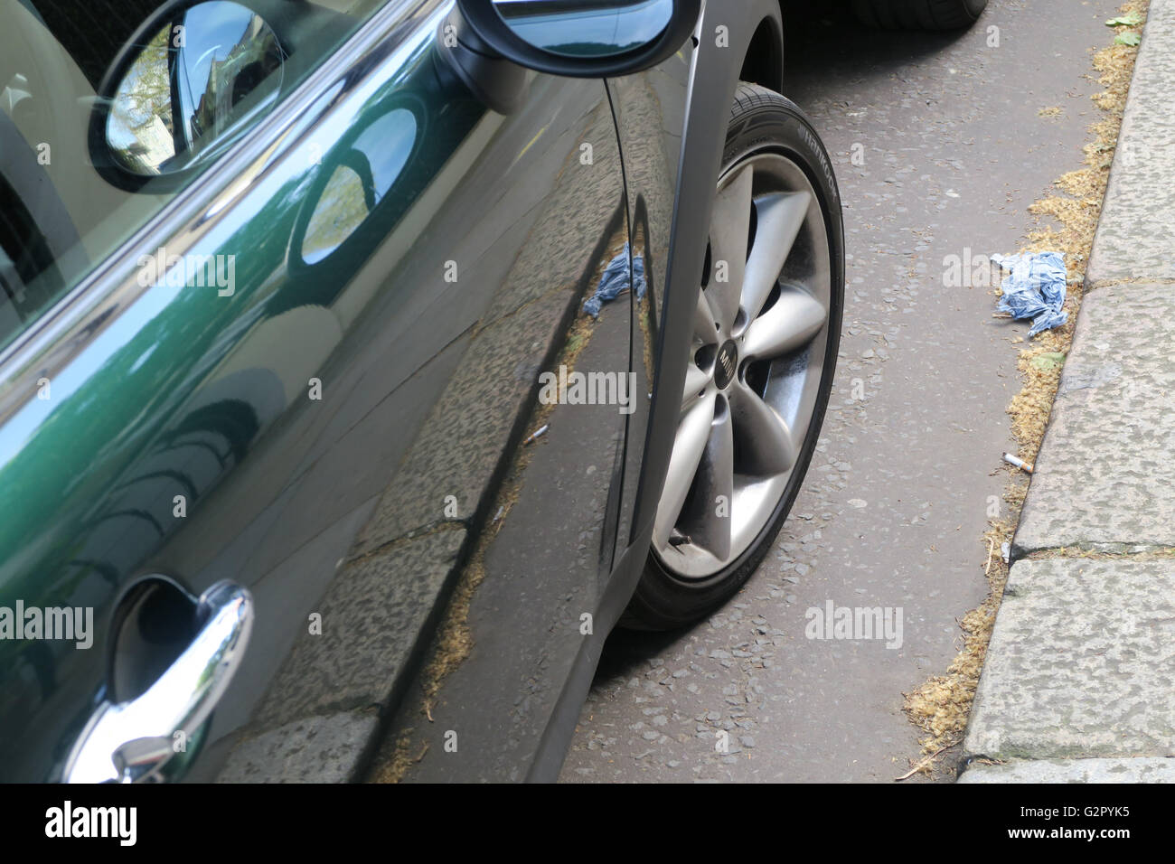 shiny green car with wheel, pavement reflected Stock Photo