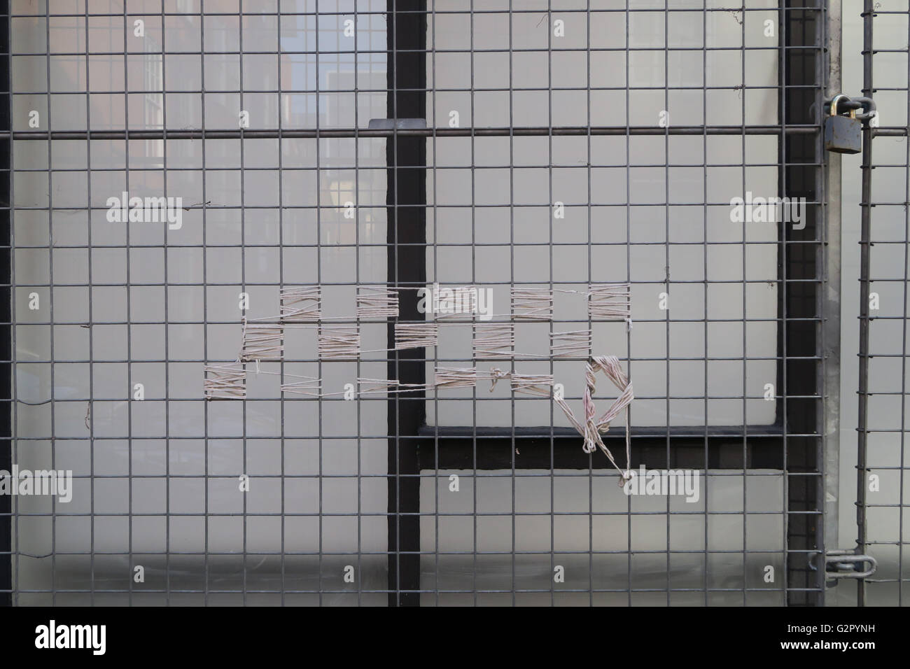 metal square fence with string pattern against glass window Stock Photo Alamy