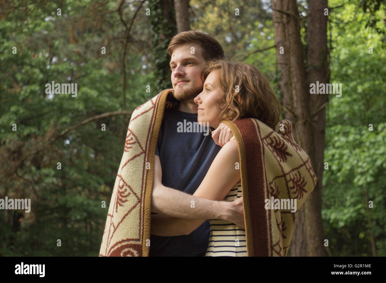 Beautiful boy girl hug couple in forest wood. Stock Photo