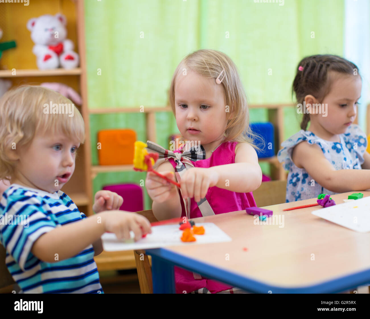 Kids or children creating arts and crafts in kindergarten. Stock Photo