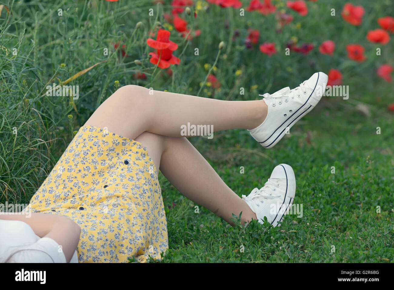 young girl  lying on poppy field Stock Photo