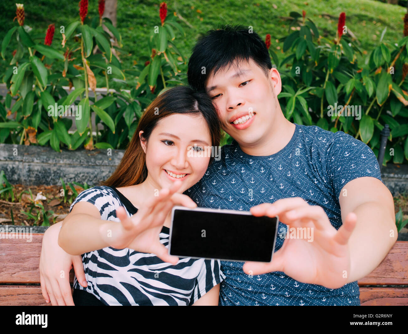 Asian couple taking a selfie photo in outdoor park scene - love and ...