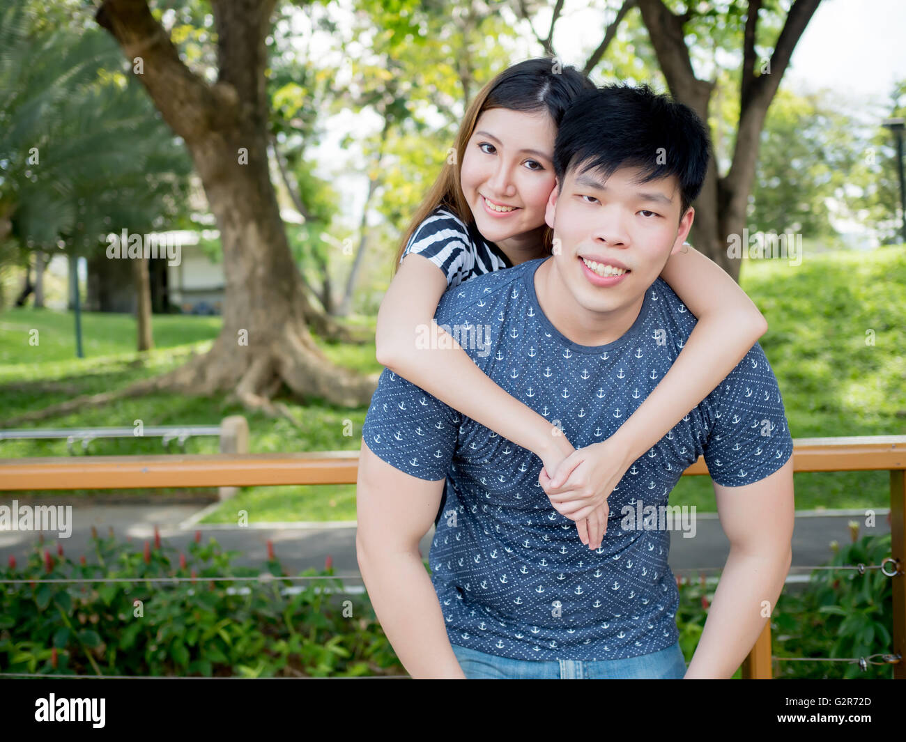 Young smiling Asian man and woman in relationship in outdoor park Stock Photo