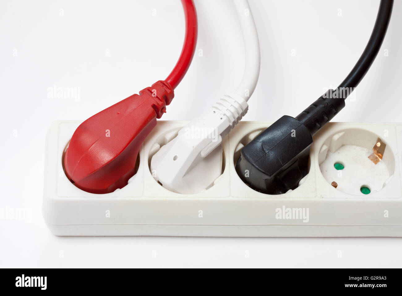 Power strip with three different coloured plugs Stock Photo