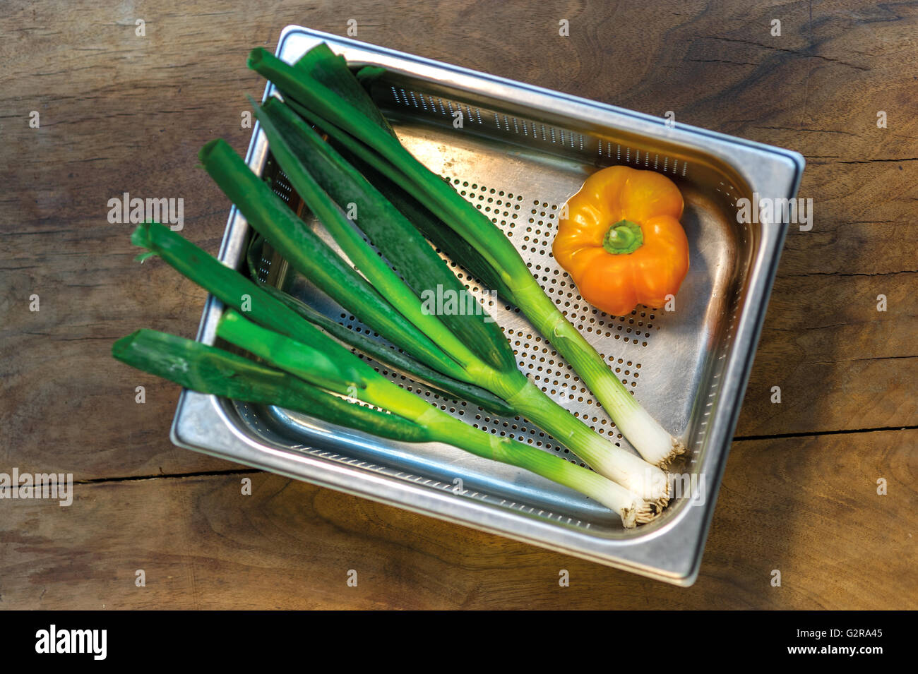 Spring onions and peppers in a colander Stock Photo