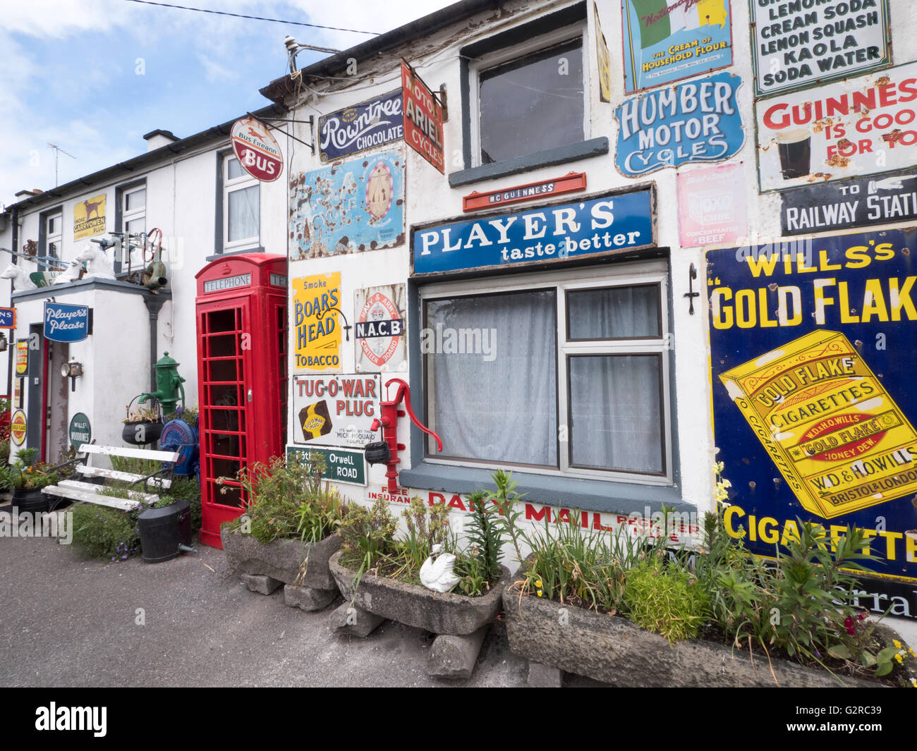 Building covered with tin advertising signs including a K6 telephone kiosk at Horseleap, County Offaly, Southern Ireland. Stock Photo