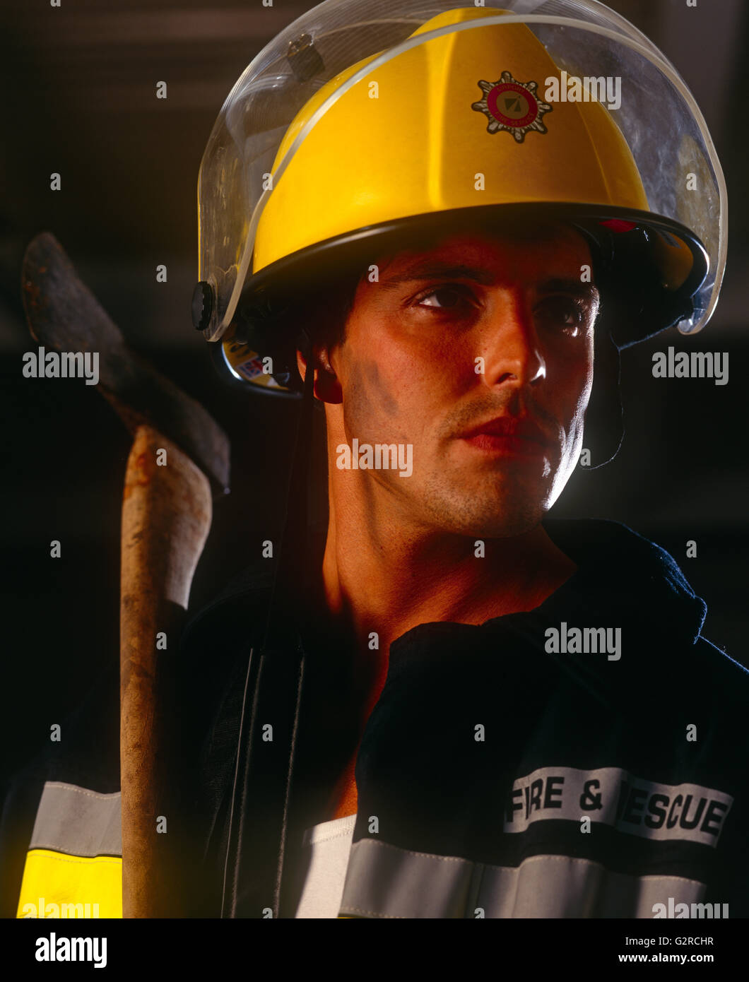 Man in a firefighter outfit, indoors. Stock Photo