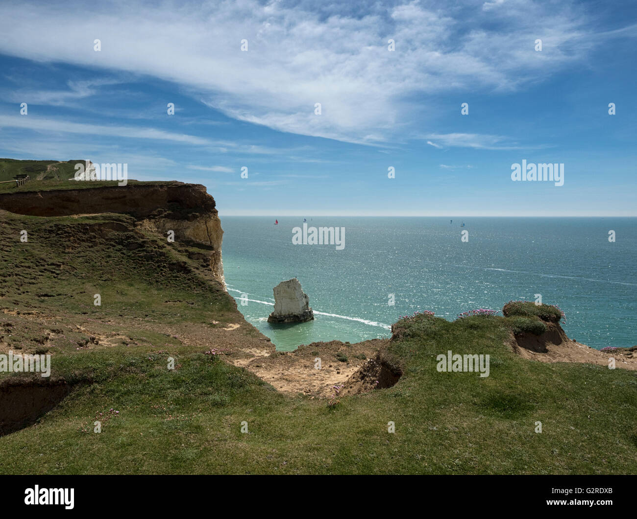 Crumbling chalk cliffs of the Sussex Downs tower above the beach at Seaford on the south coast of England, UK Stock Photo