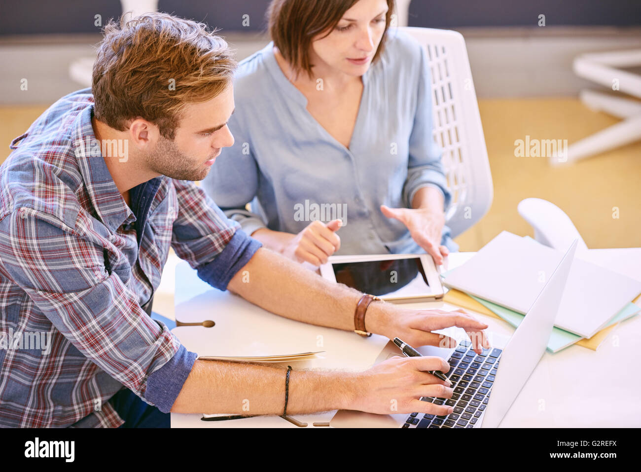 Male and female professional working together to achieve more Stock Photo