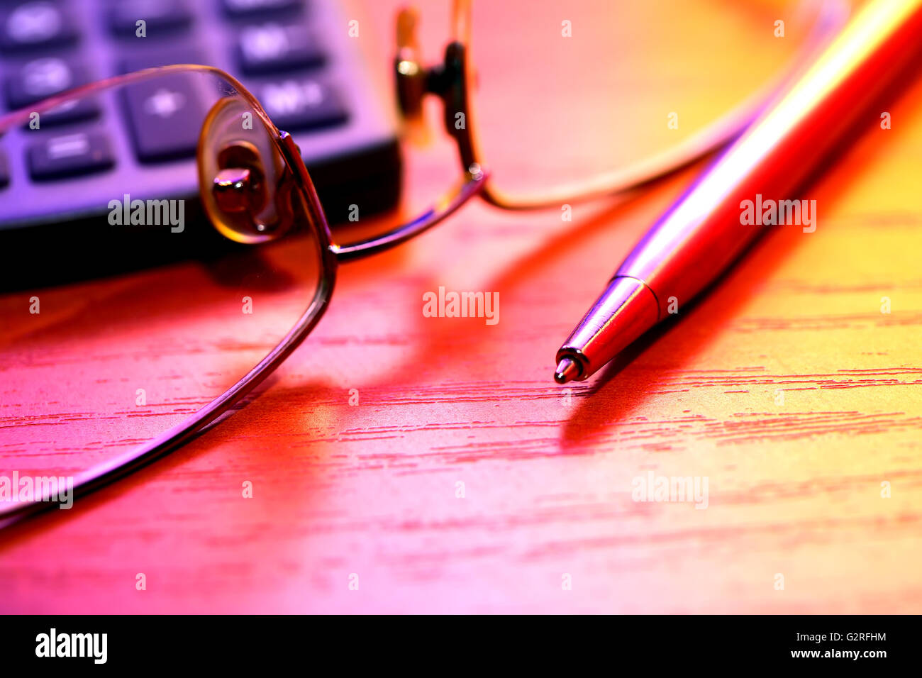 Colorful still life with pen near spectacles and calculator Stock Photo
