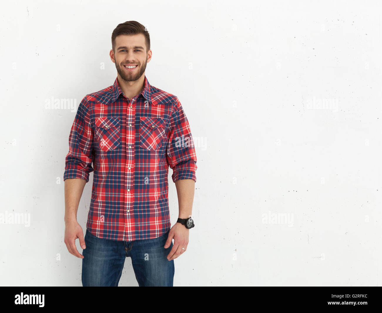 Portrait of handsome young guy standing against white wall Stock Photo ...