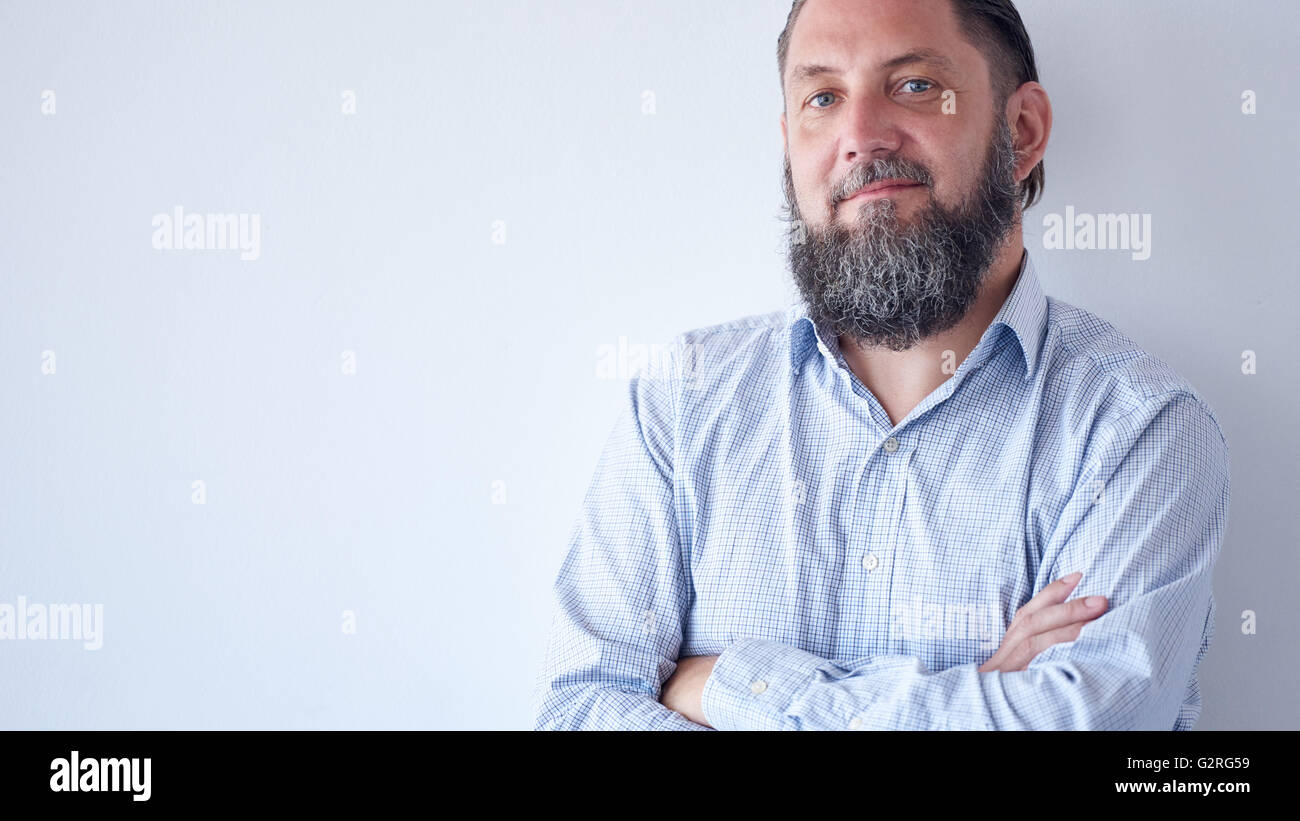 Mature man with arms crossed smiling at camera Stock Photo - Alamy