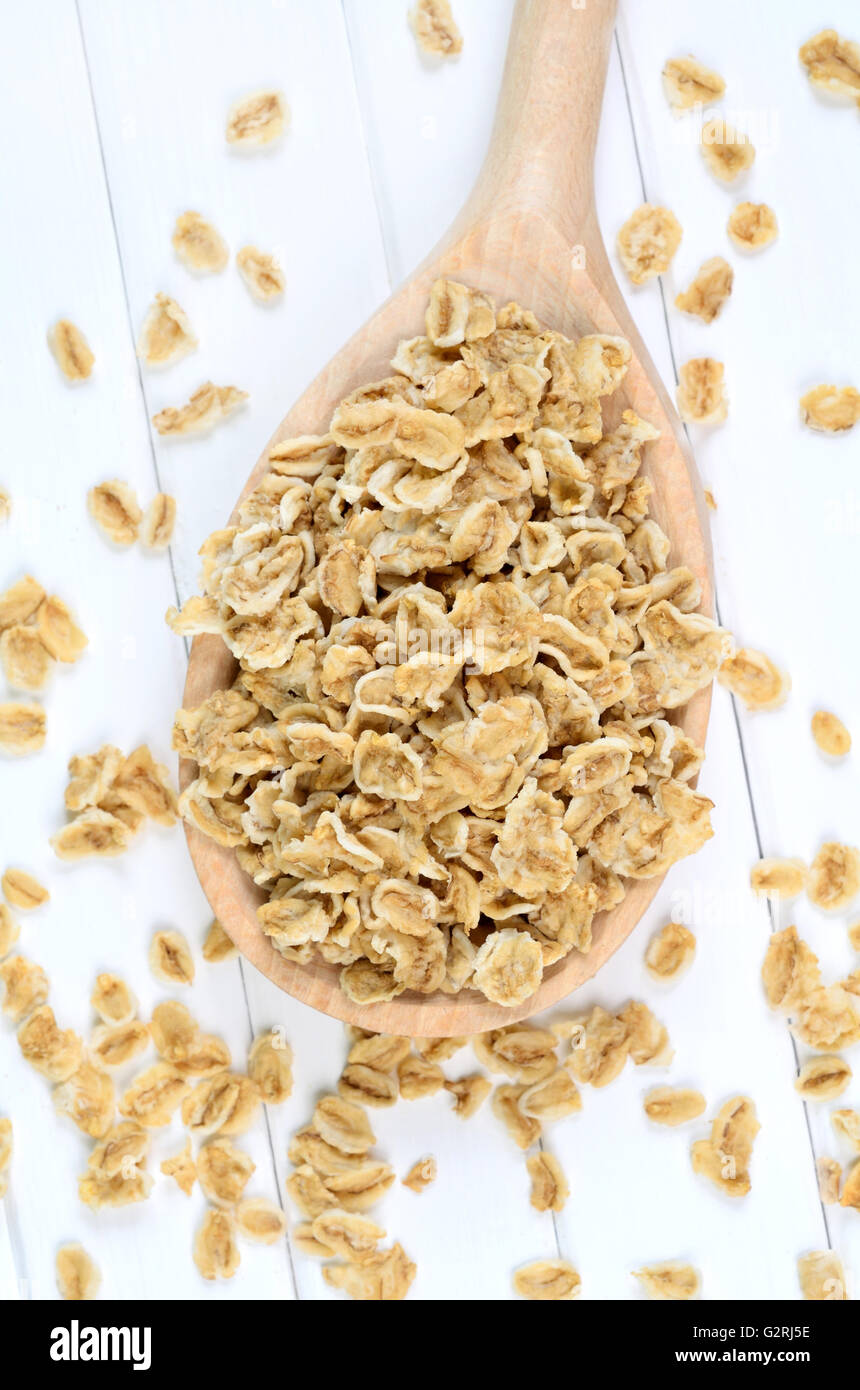 Spoon with oats on wooden table Stock Photo