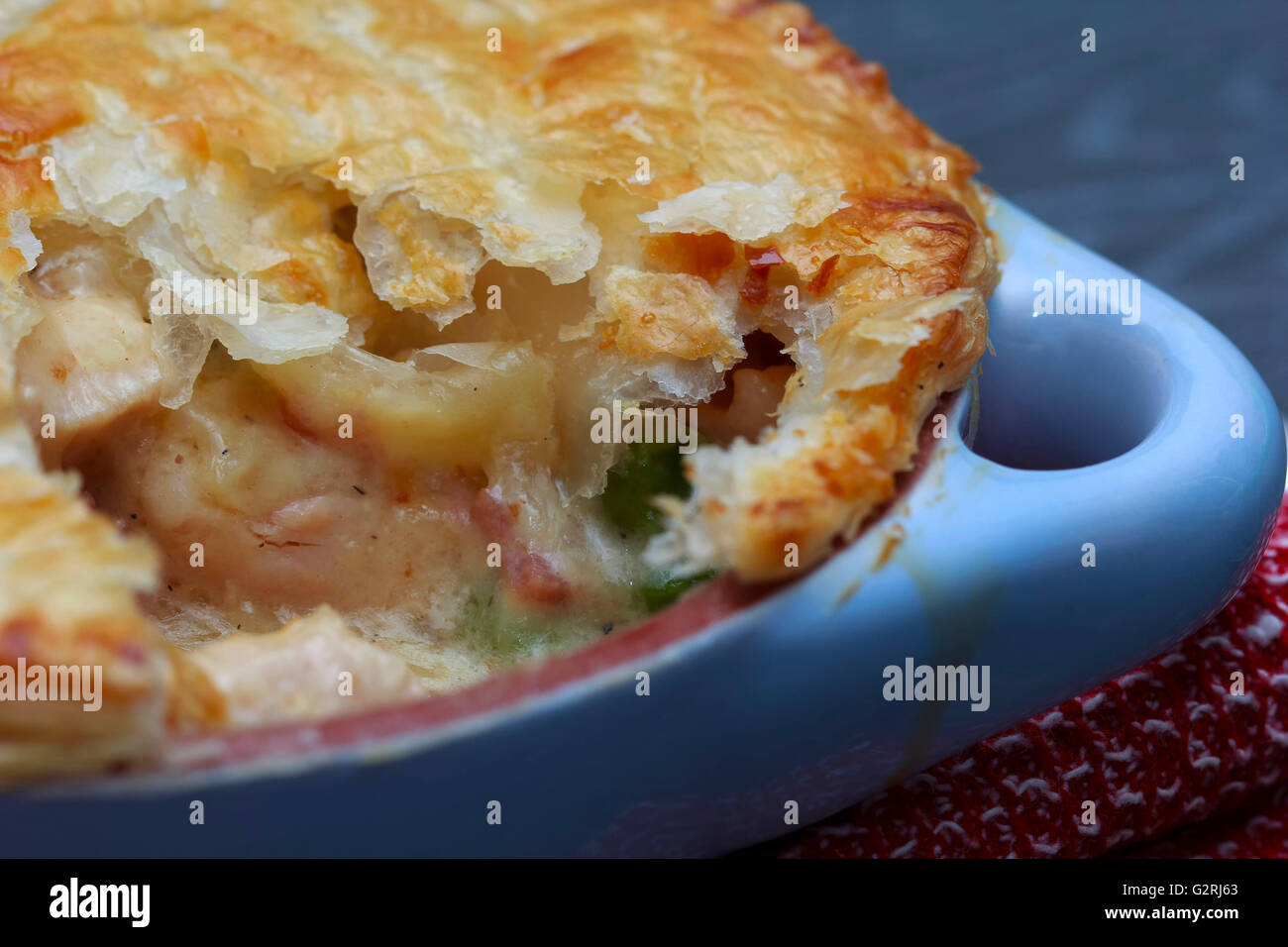 Chicken and bacon pot pie with cheese on wooden table Stock Photo