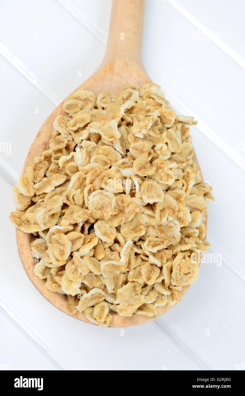 Oat flakes in wooden spoon on table Stock Photo