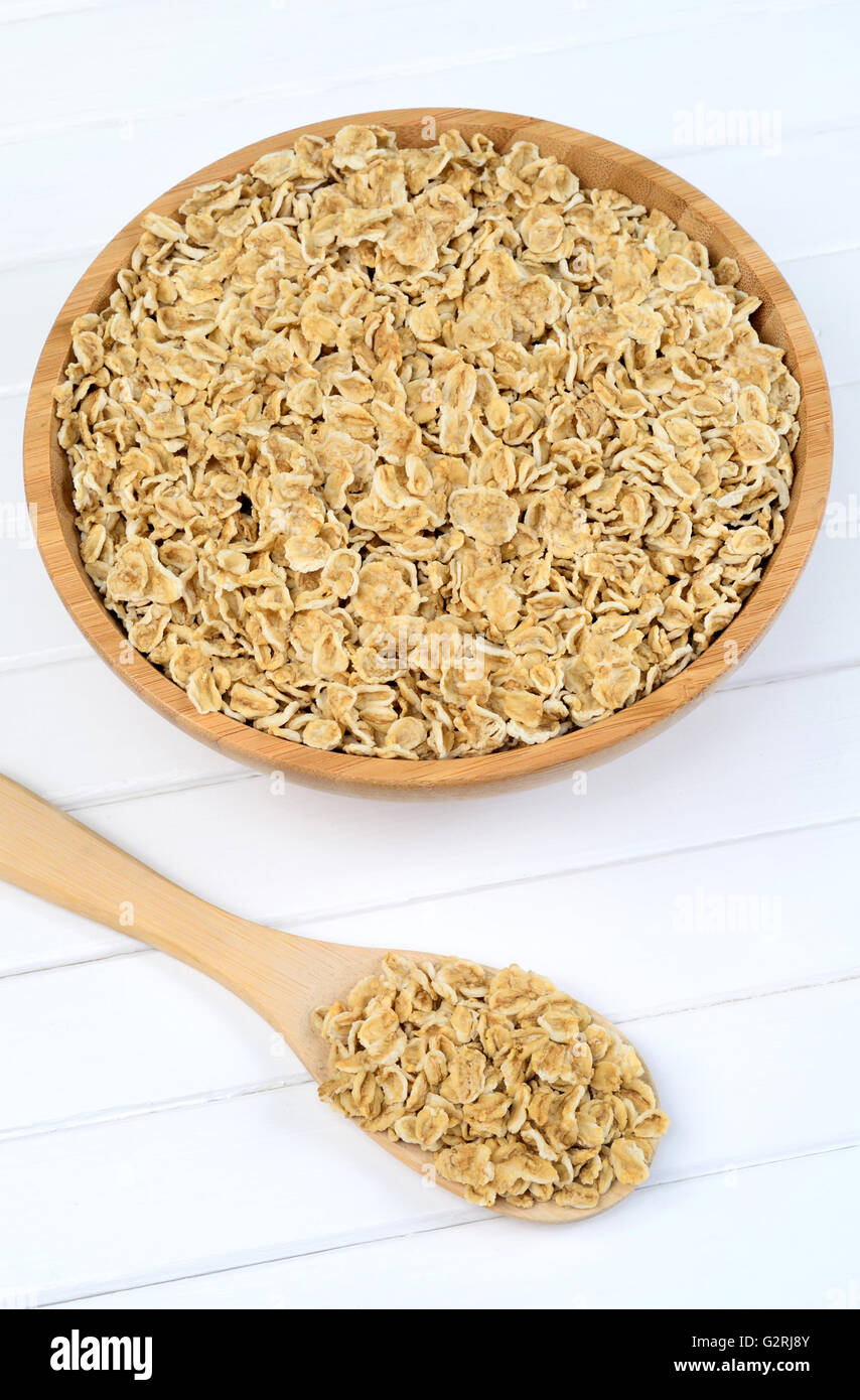 Oat flakes in bamboo bowl on white wooden table Stock Photo