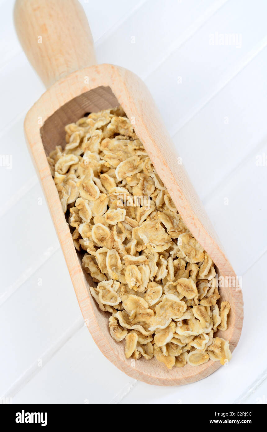 Oat flakes in wooden scoop Stock Photo