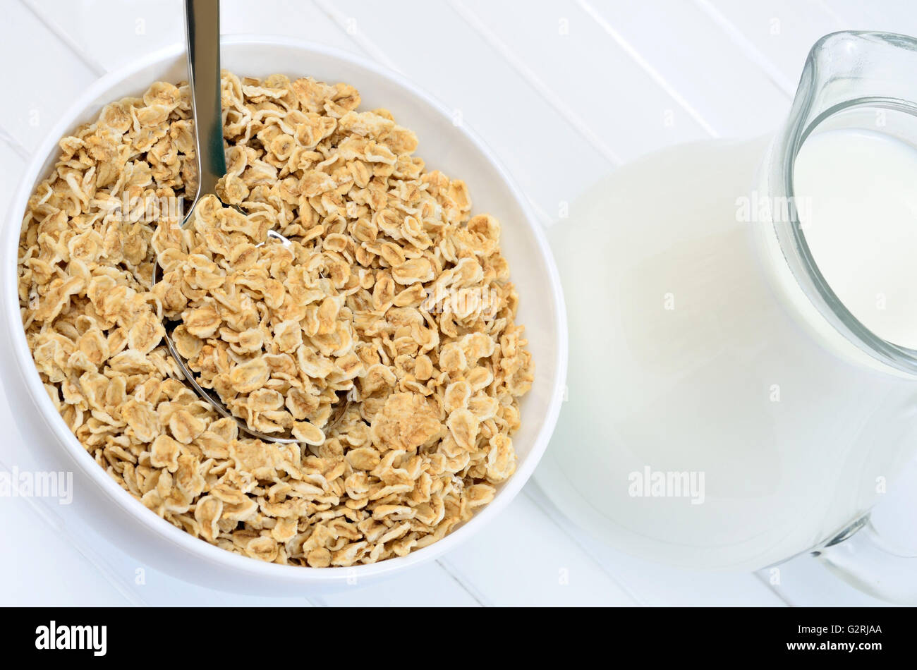 White bowl with oat flakes and milk on wooden table Stock Photo