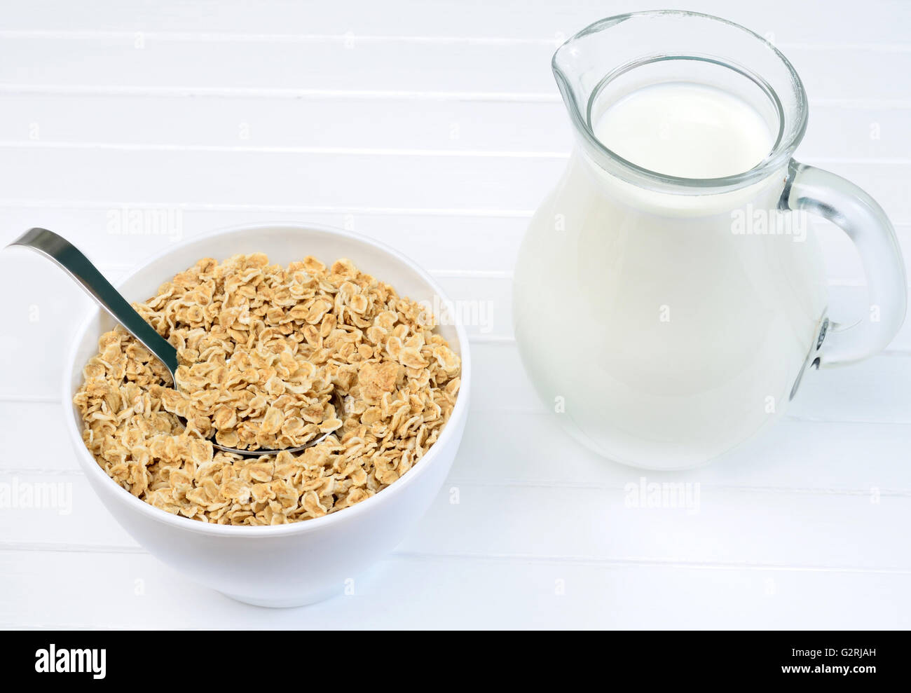 Bowl with oatmeal and milk on white wooden table Stock Photo