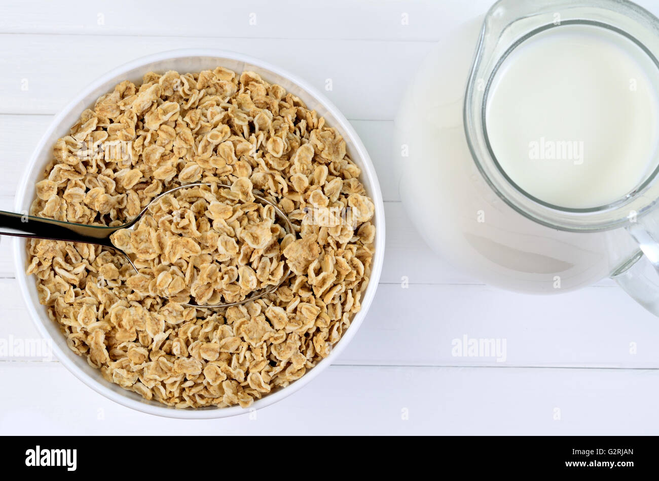 Bowl with healthy oats and milk on white wooden table Stock Photo