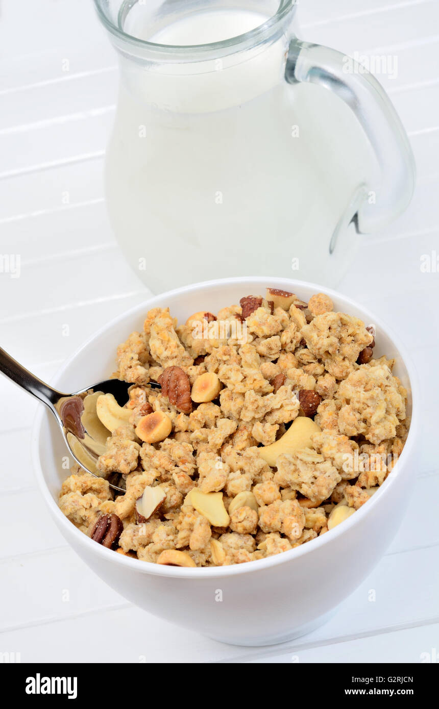 Delicious muesli in white bowl and milk on wooden table Stock Photo