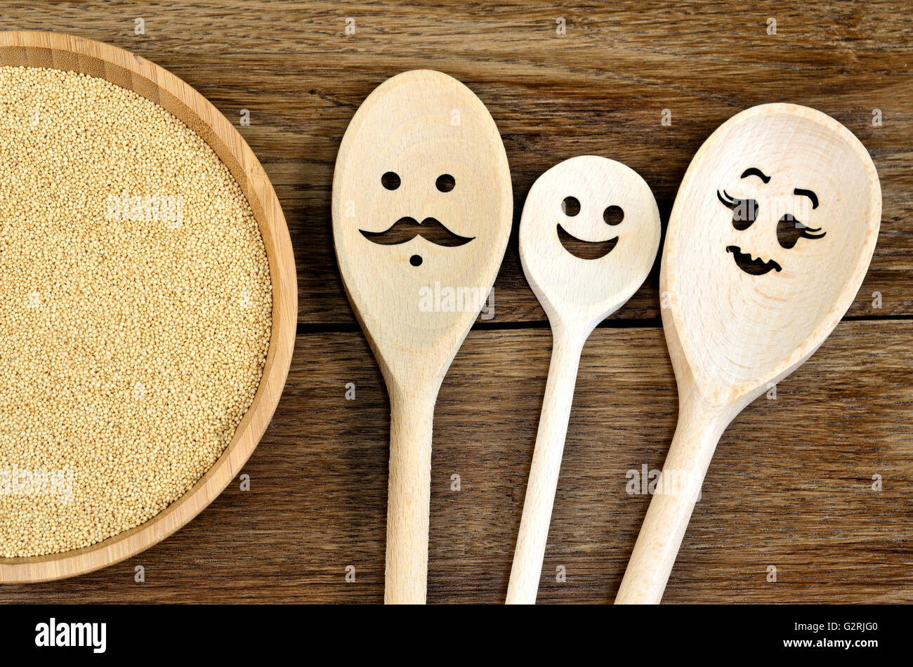 Family wooden spoon with amaranth seeds in a bamboo bowl on wooden table Stock Photo