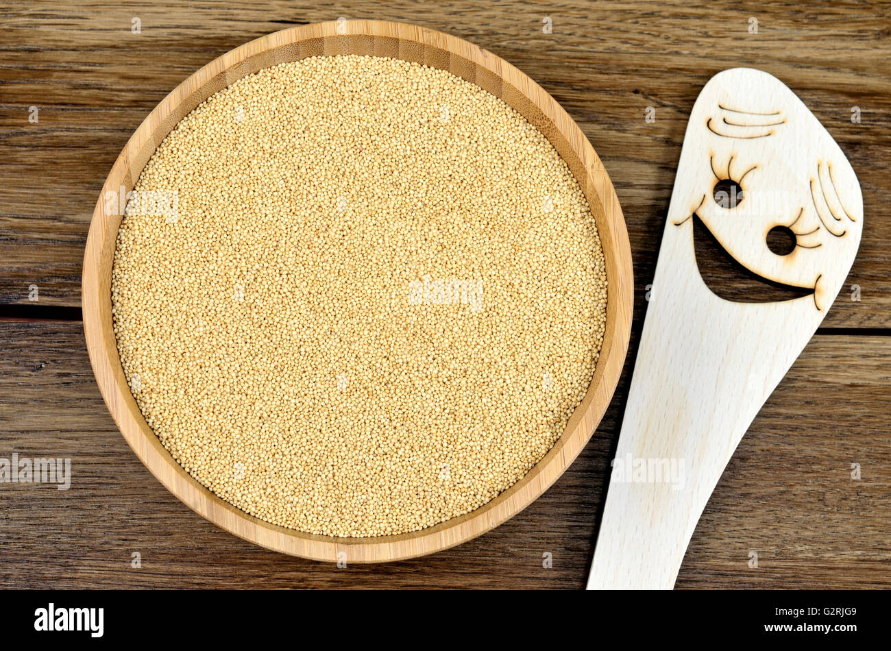 Wooden spoon with smile shape and amaranth seeds in a bamboo bowl Stock Photo