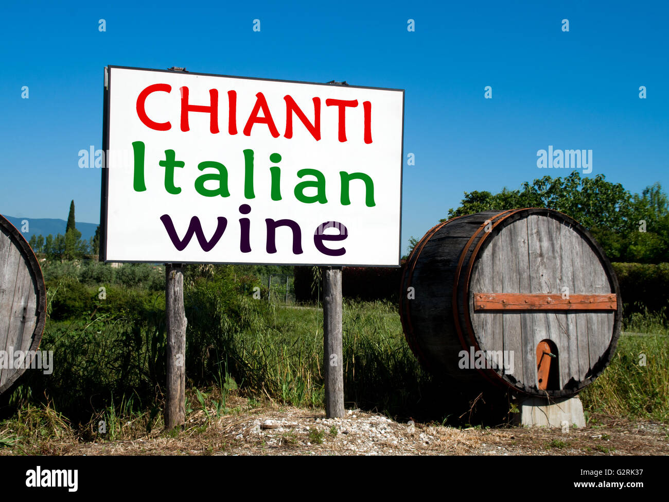 Traditional wooden barrel with a billboard that advertises the sale of wine in the Tuscan countryside Stock Photo