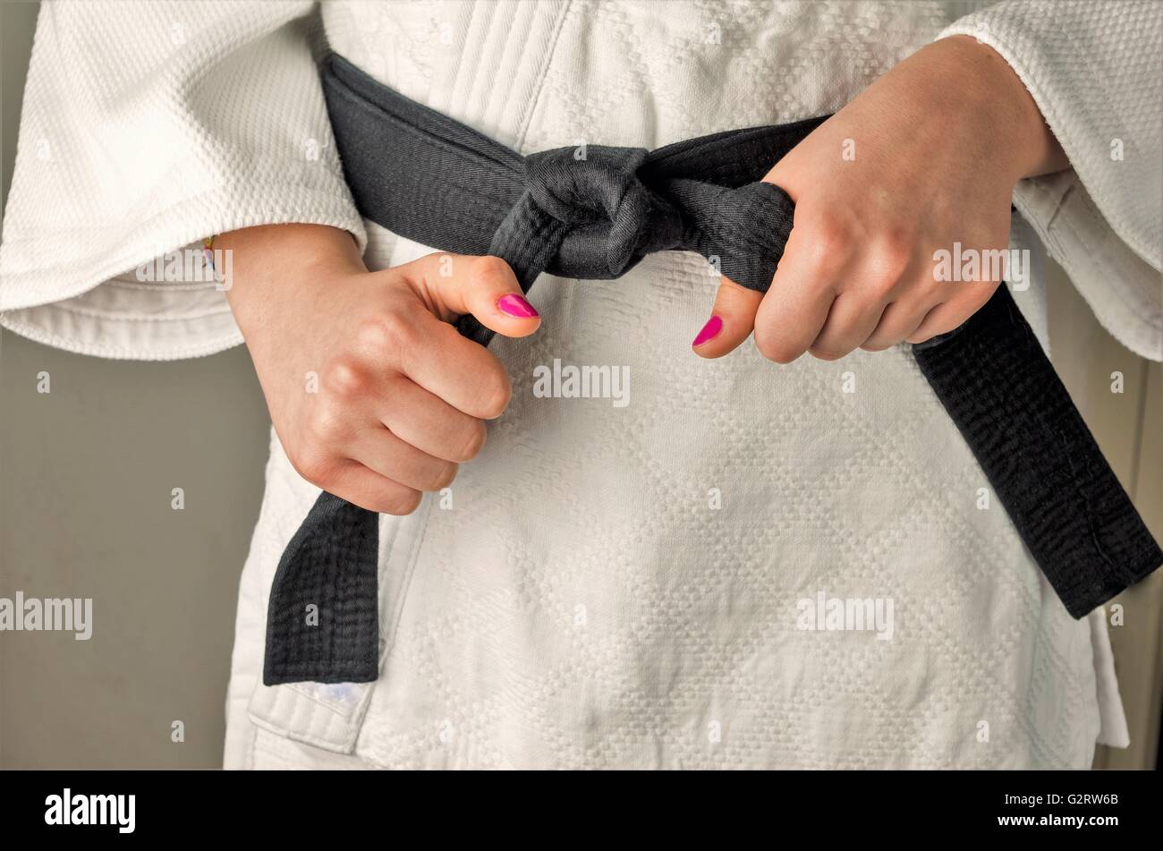 Hands with nail polish of a girl with a black belt in martial arts, close up Stock Photo