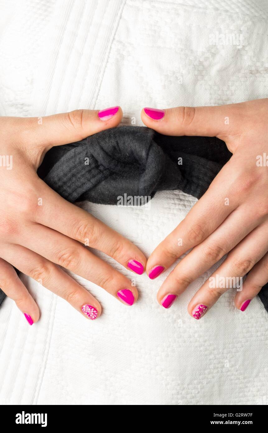 Hands with nail polish of a girl with a black belt in martial arts, close up Stock Photo