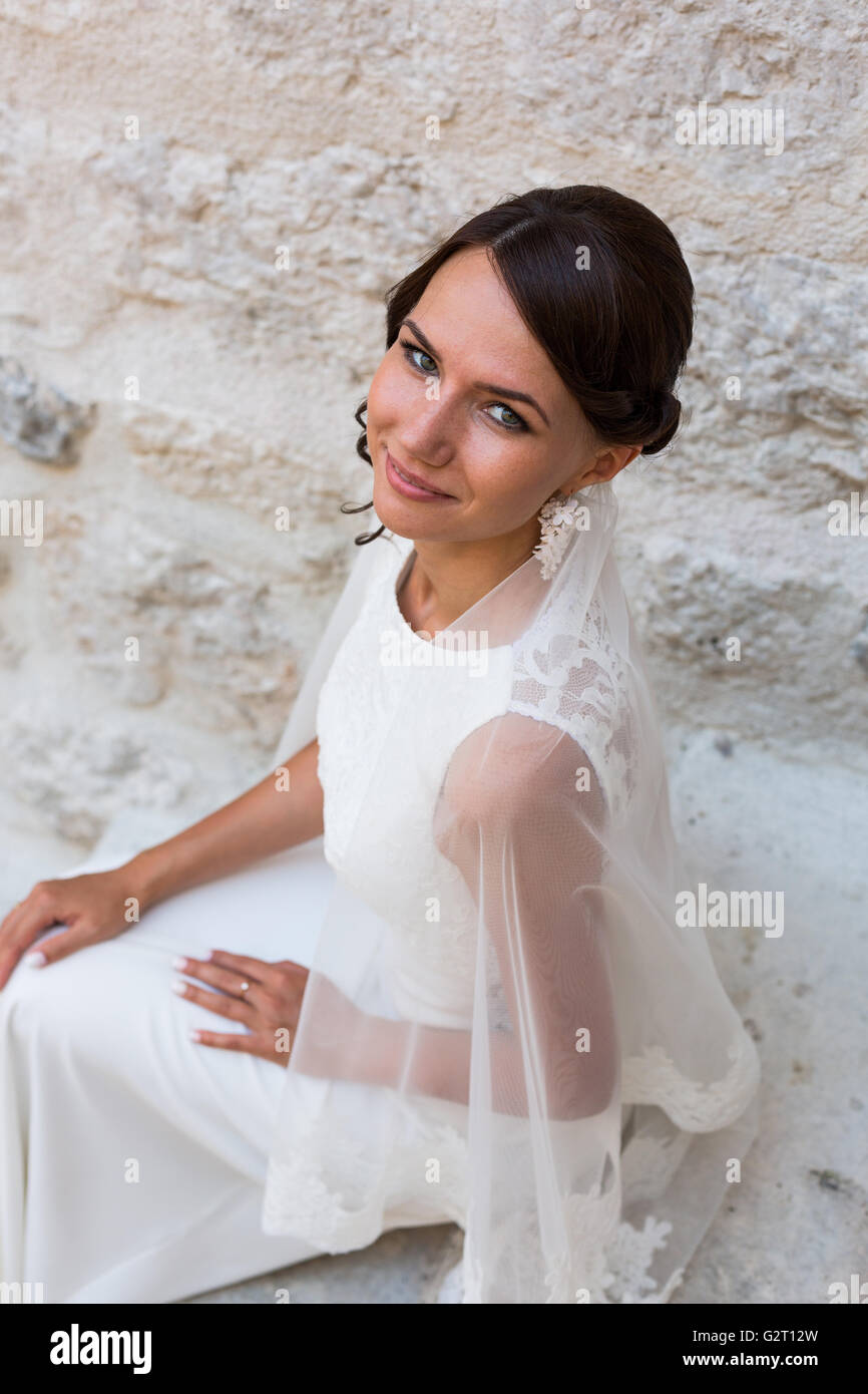 Beautiful bride outdoors posing on the steps Stock Photo - Alamy