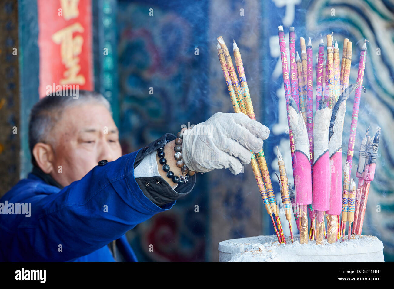 Man burning incense in Xishan Forest Park, Kunming, Yunnan, China Stock
