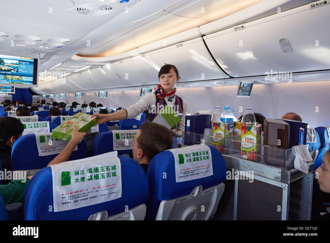 China Eastern Airlines Flight Attendant Passing Out Meals Stock