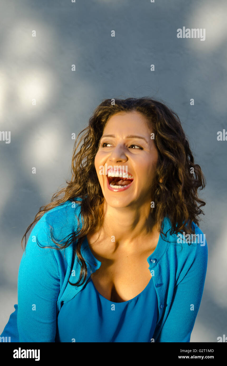 Studio portrait of mid age Hispanic woman laughing Stock Photo
