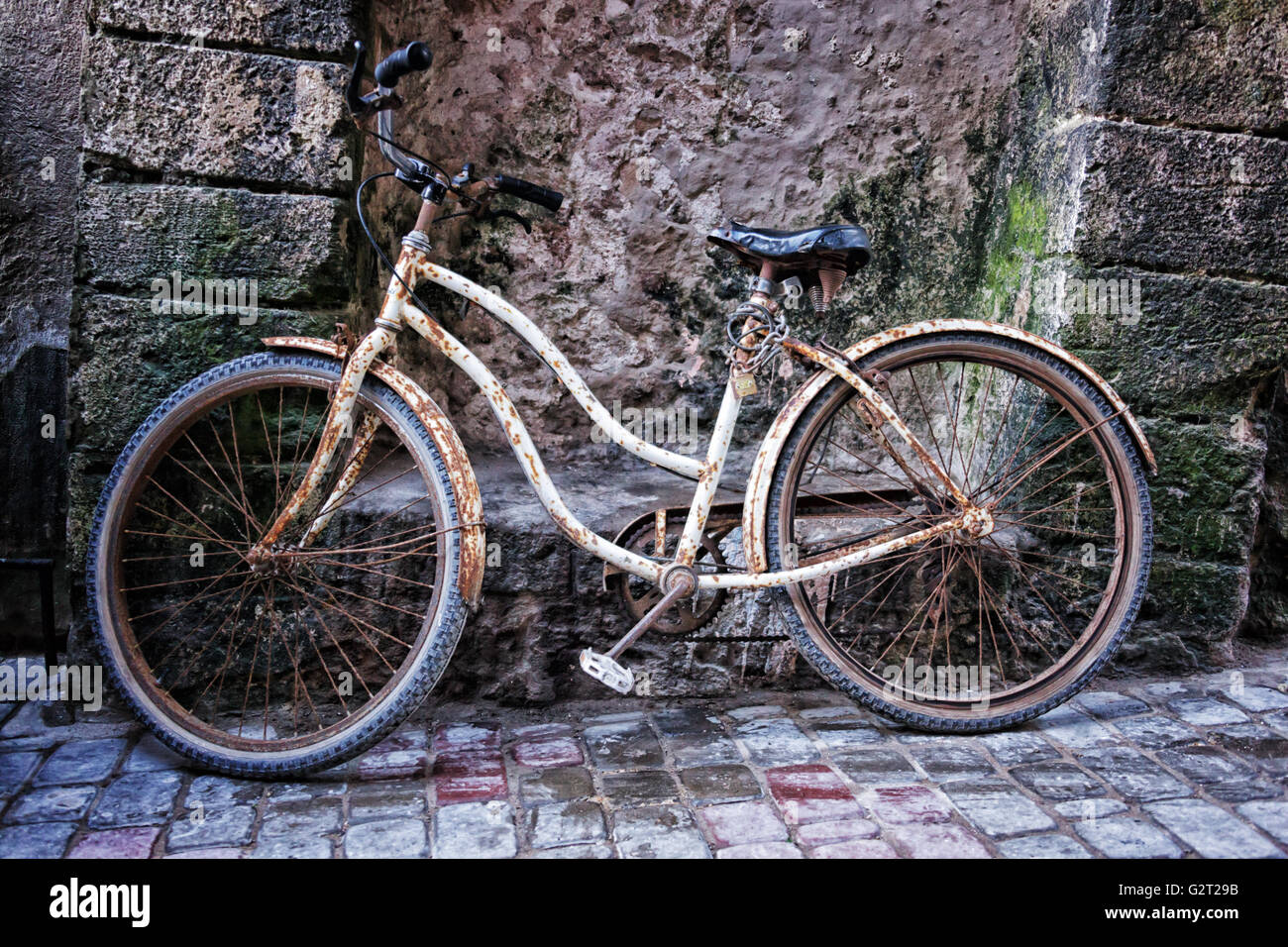 Old bicycle against  decayed wall at the harbor in Essaouira, Morocco. Stock Photo