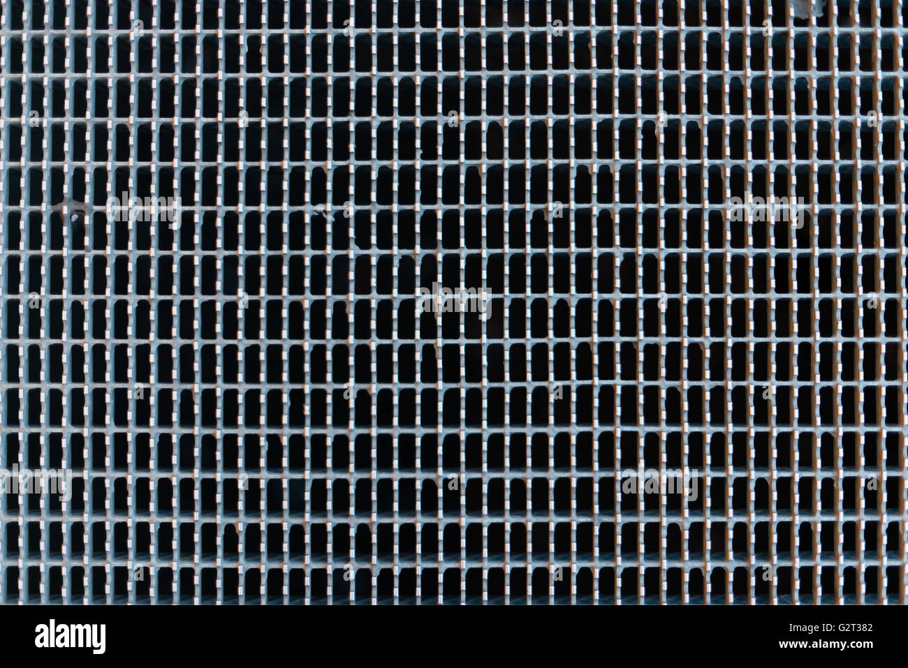 Iron grid with rectangular pattern symbolizing a wall, border or fence containing repetitive patterns resulting from industrial Stock Photo
