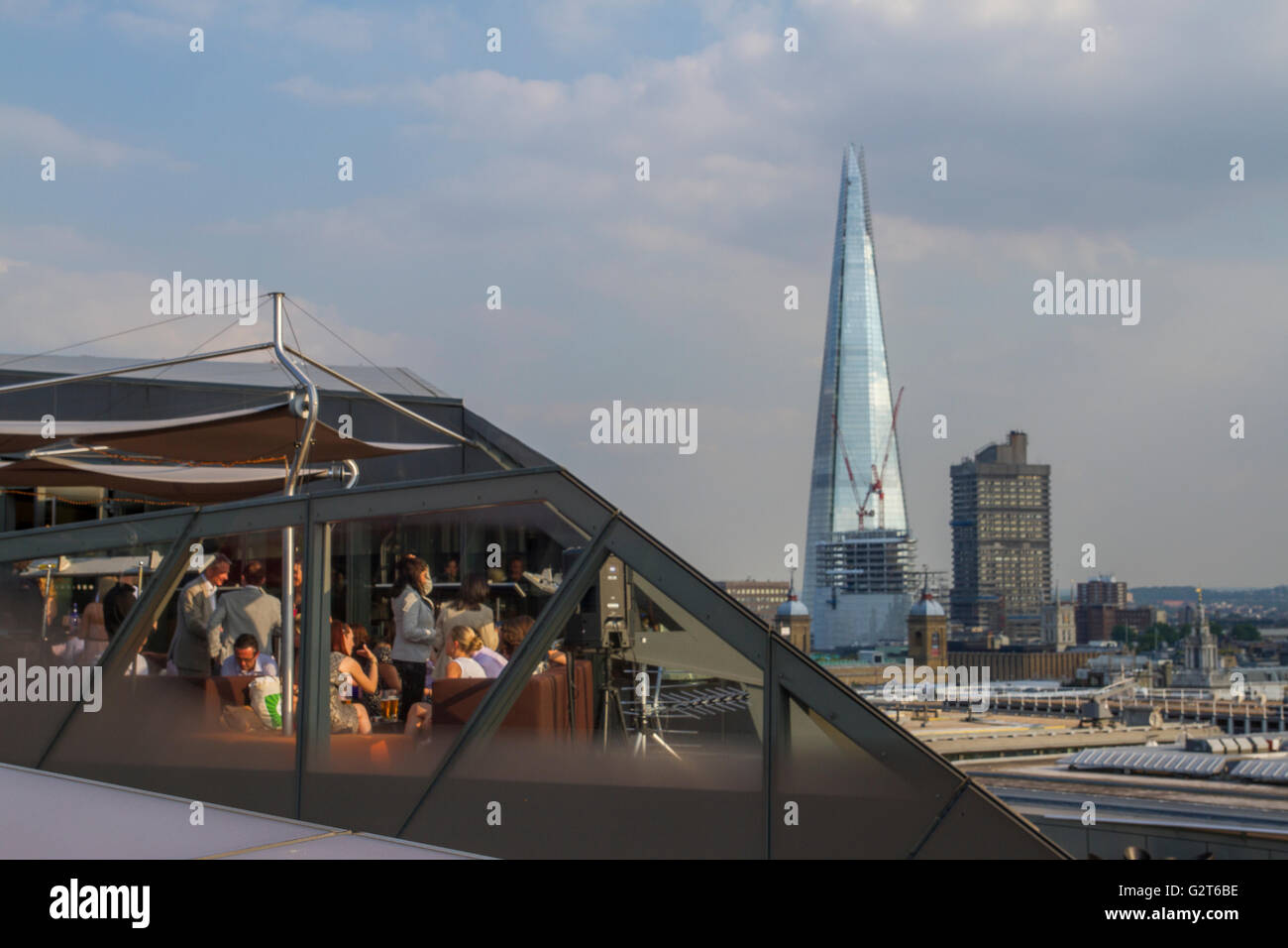Diners enjoying food and drinks at Madison Rooftop Bar & Restaurant One New Change, With The Shard in The Distance Stock Photo