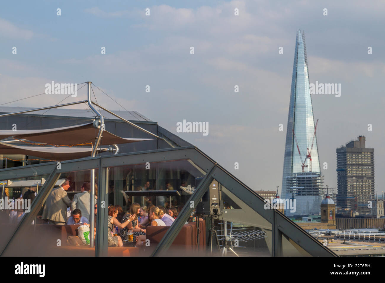 Diners enjoying food and drinks at Madison Rooftop Bar & Restaurant One New Change, With The Shard in The Distance Stock Photo