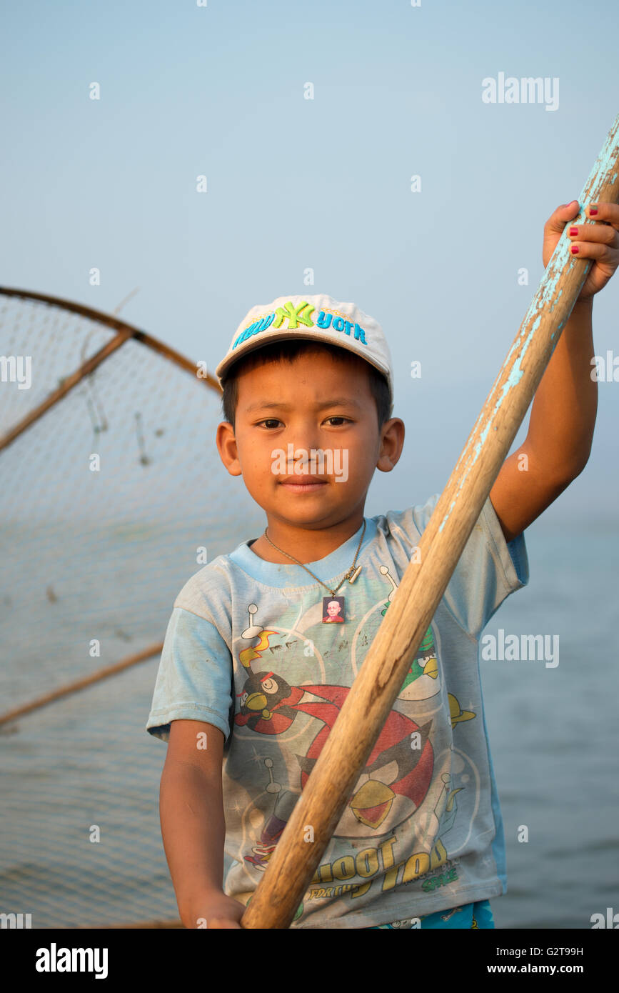 Young Intha fisherman using an oar, Inle Lake, Myanmar Stock Photo