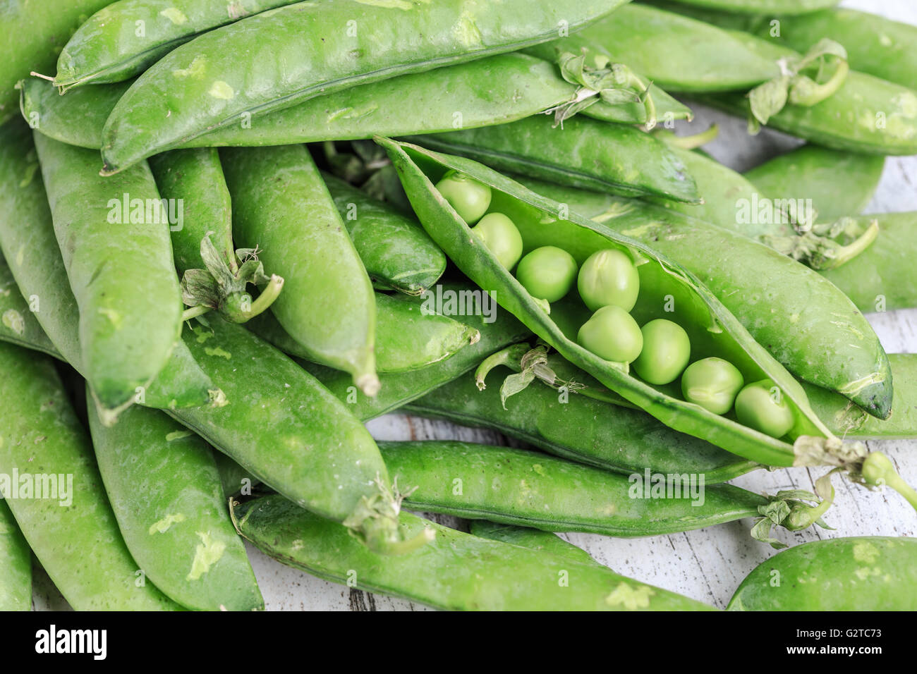 Green fresh peas pods on a wooden background Stock Photo