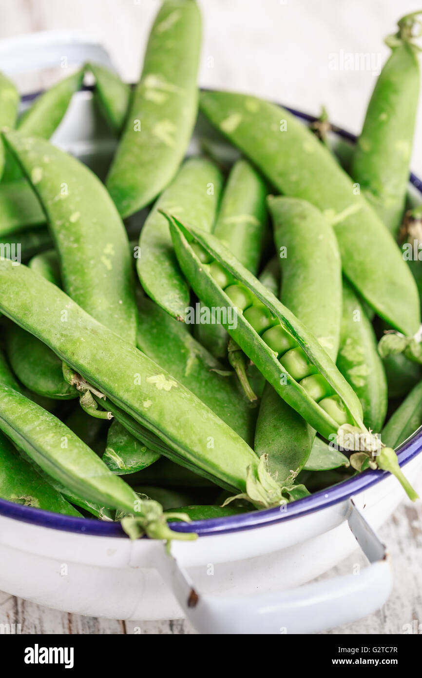Pods of green fresh peas in a bowl Stock Photo