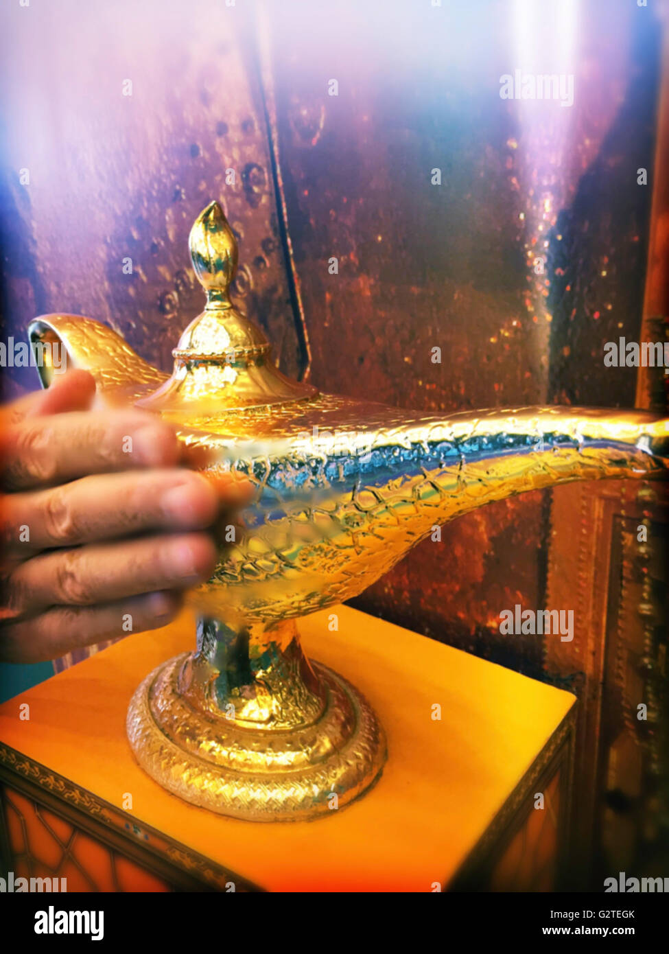 Man Rubbing Genie's Magic Golden Lamp Stock Photo