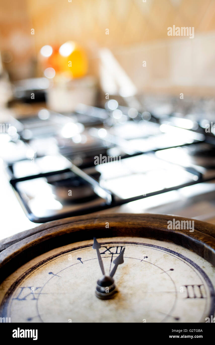 concept of lunch time with an old skeleton clock on a stove-top Stock Photo