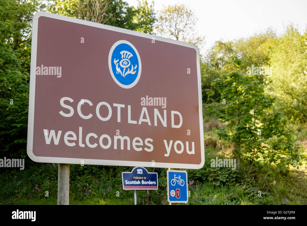 Scotland Welcomes You road sign on English Scottish border with cycle route 1 sign. Berwickshire Scottish Borders Scotland UK Stock Photo