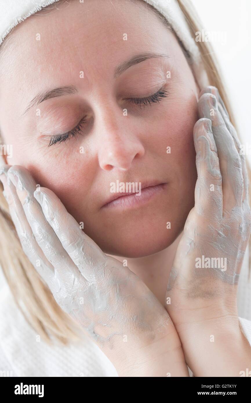 Young woman putting cream on her face Stock Photo Alamy